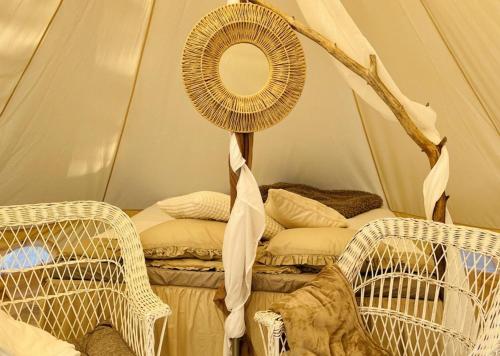 a room with a tent with a mirror and wicker chairs at tent romantica a b&b in a luxury glamping style in Mariefred