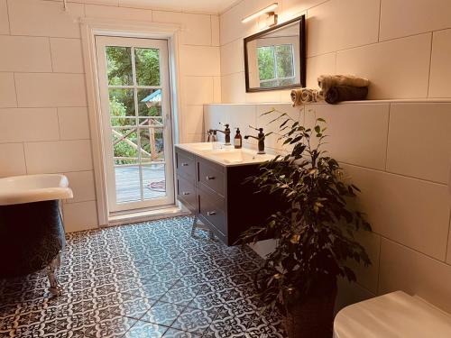 a bathroom with a sink and a plant in it at tent romantica a b&b in a luxury glamping style in Mariefred