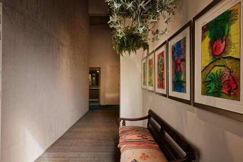a hallway with a bench and paintings on the wall at Hotel Miss Blanche in Groningen