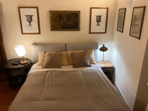 um quarto com uma cama com um candeeiro e fotografias na parede em Central and quiet apartment em Florença