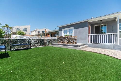 un patio con bancos y césped frente a una casa en A Place to Create Lasting Family Memories en San Diego