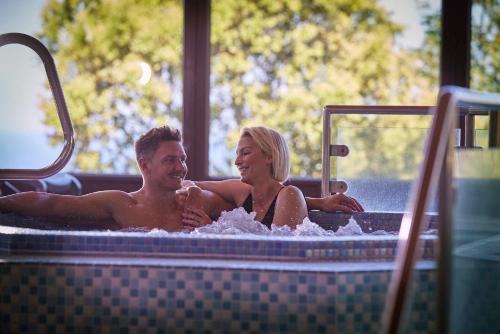 a man and woman sitting in a hot tub at Gwel an Mor in Portreath