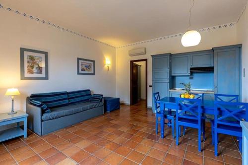sala de estar con sofá azul y mesa en Appartamento villaggio Calamancina San Vito Lo Capo, en San Vito lo Capo