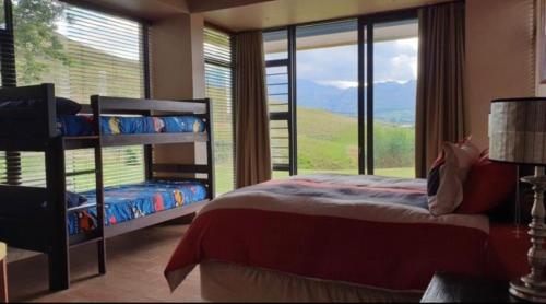 ein Schlafzimmer mit einem Etagenbett und einem großen Fenster in der Unterkunft Cathkin in Ardmore