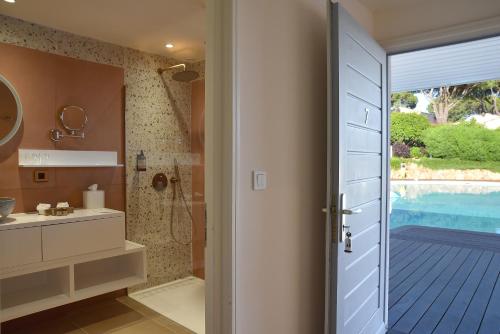 a bathroom with a shower and a sink and a door at Hôtel Alivi Di Santa Giulia in Porto-Vecchio