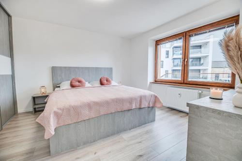1 dormitorio con cama rosa y ventana en Nitra Castle Suite - Modern Elegance & Serenity, en Nitra