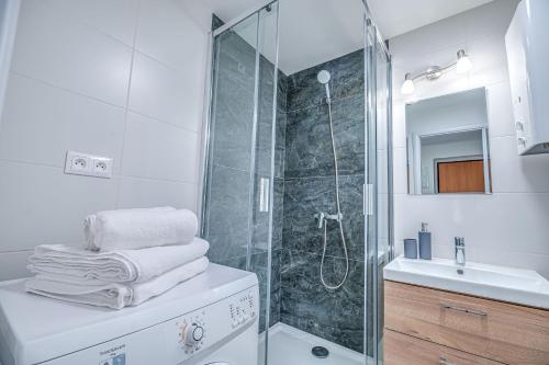 a white bathroom with a shower and a sink at Nitra Castle Suite - Modern Elegance & Serenity in Nitra