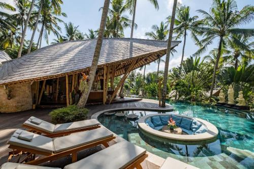 ein Resort mit einem Pool und Palmen in der Unterkunft Harmony House, Bamboo House with Pool view in Bringkit