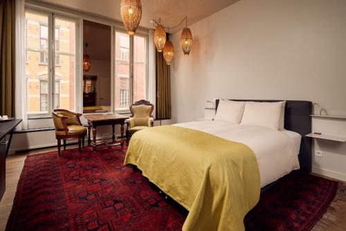 a bedroom with a bed and a table and chairs at Hotel Miss Blanche in Groningen