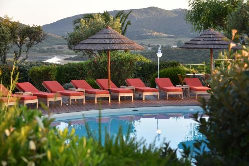 a group of chairs and umbrellas next to a pool at Hôtel Alivi Di Santa Giulia in Porto-Vecchio