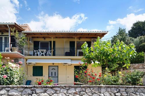 a yellow house with a balcony and some flowers at Vardia studio A in Mikros Gialos