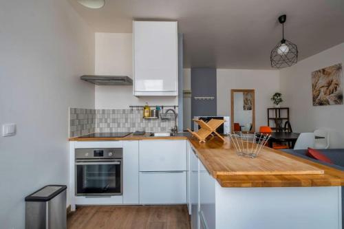 une cuisine avec des armoires blanches et un comptoir dans l'établissement Volcano, à Reims