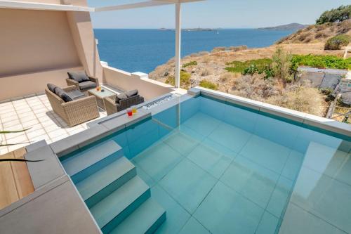 a swimming pool with a view of the ocean at Aegean Glory Suites in Ermoupoli