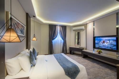 a hotel room with a large bed and a flat screen tv at Boudl Al Fayhaa in Riyadh