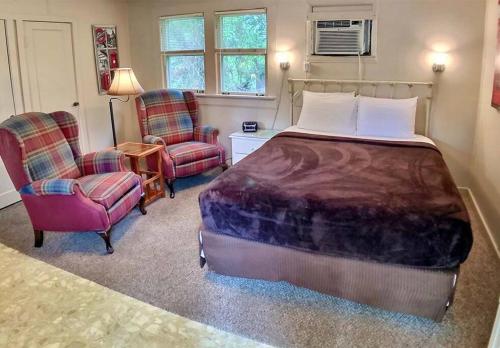 1 dormitorio con 1 cama y 2 sillas en The London Flat #4/ Oak Crest, en Eureka Springs