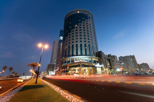 a tall building on a city street at night at Kuwait Grand Hotel in Kuwait