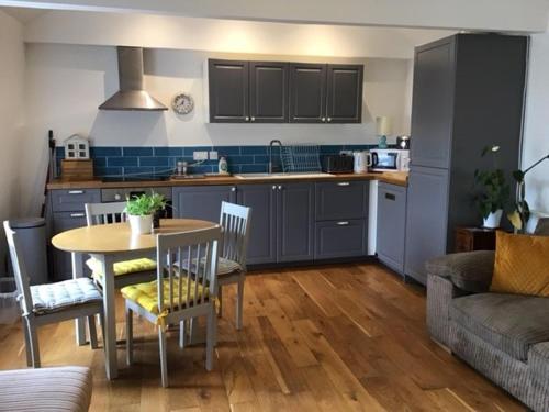 a kitchen and living room with a table and a couch at Central Teignmouth Penthouse Sleeps 4 Pets Ok in Teignmouth