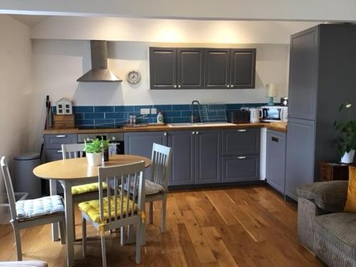 a kitchen with a table and a kitchen with blue cabinets at Stunning penthouse apartment in Teignmouth in Teignmouth
