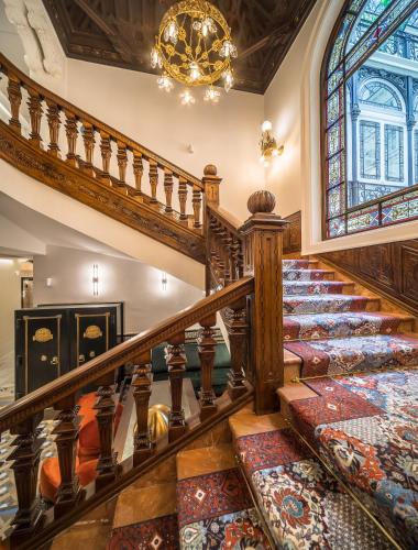 an ornate staircase in a home with a stained glass window at Palacio Gran Vía, a Royal Hideaway Hotel in Granada
