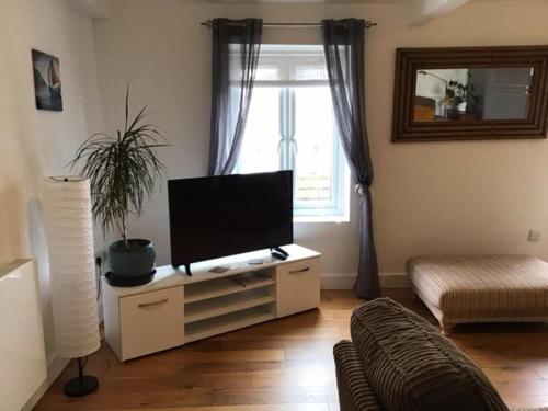 a living room with a flat screen tv on a cabinet at Central Teignmouth Penthouse Sleeps 4 Pets Ok in Teignmouth