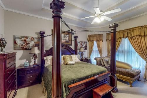 a bedroom with a canopy bed and a ceiling fan at The Perfect Getaway in Atlanta