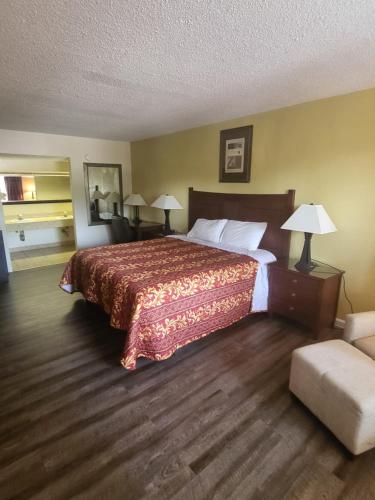 a hotel room with a large bed and a couch at America's Inn Williamsburg in Williamsburg