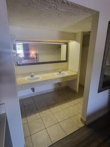 baño con 2 lavabos y espejo grande en America's Inn Williamsburg, en Williamsburg