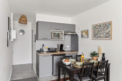 une petite cuisine avec une table et un micro-ondes dans l'établissement Nid douillet proche gare, à Nantes