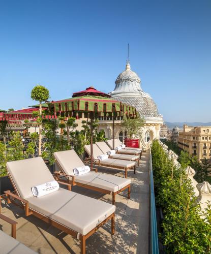 a row of chaise lounge chairs on the roof of a building at Palacio Gran Vía, a Royal Hideaway Hotel in Granada