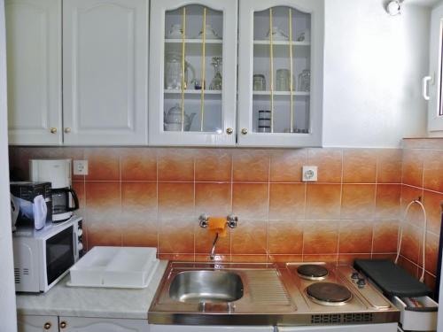 a kitchen with a sink and white cabinets at Alemka in Banjol