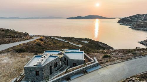 a house on a hill next to a body of water at MYRTOS in Karistos