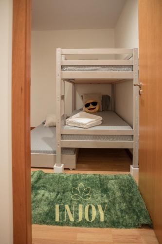 a room with two bunk beds and a green rug at Enjoy Flat by TonsdeVerde in Braga