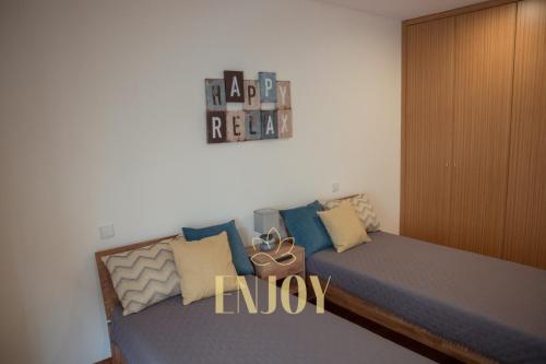 a bedroom with a bed with pillows on it at Enjoy Flat by TonsdeVerde in Braga