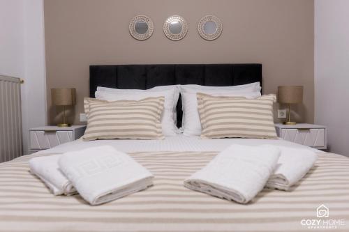uma cama com cobertores brancos e almofadas em Cozyhome3 Navarinou em Tessalônica