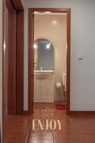 a bathroom with a sink and a mirror at Enjoy Flat by TonsdeVerde in Braga