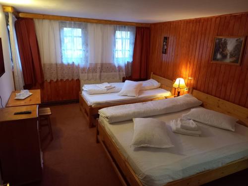 a hotel room with two beds and a lamp at Casa Ardeleană Cheia in Cheia