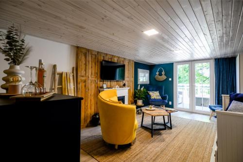 a living room with a yellow chair and blue walls at REDIBO Erdei Vendégház in Kismaros