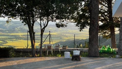 una mesa y sillas sentadas bajo los árboles con vistas en Villa CAPOROTONDO en Pisticci