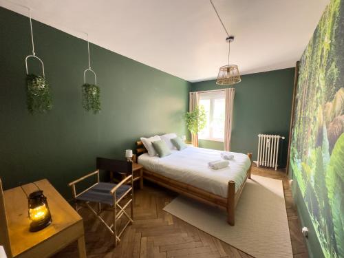 una camera da letto con un letto e una parete verde di Jungle Urbain- Sauna - Ciné - Hamac - Hyper centre ad Amiens