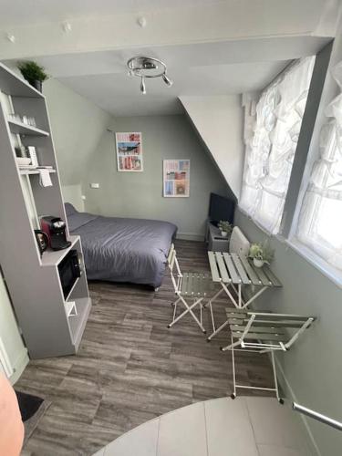 une chambre avec un lit et une table dans une pièce dans l'établissement Studio centre historique de Rouen, à Rouen