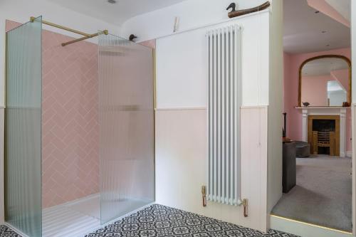 - une porte de douche en verre dans une pièce avec cheminée dans l'établissement The Cors Country House, à Laugharne