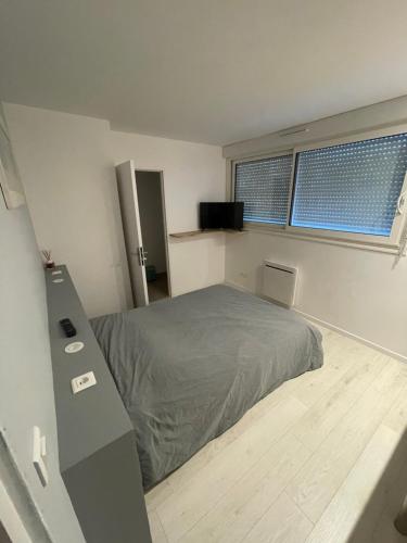 1 dormitorio con 1 cama y TV en chambre etage fonctionnelle et independante, en Saucats