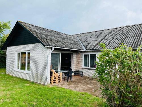 a white house with a patio with a table at Scandinavian House Hotel- Holbøl, Kruså in Kruså