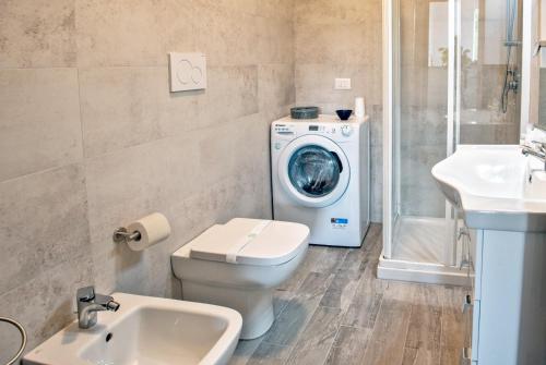 uma casa de banho com uma máquina de lavar roupa e uma máquina de lavar roupa em “villa Francesco” em Nizza Monferrato