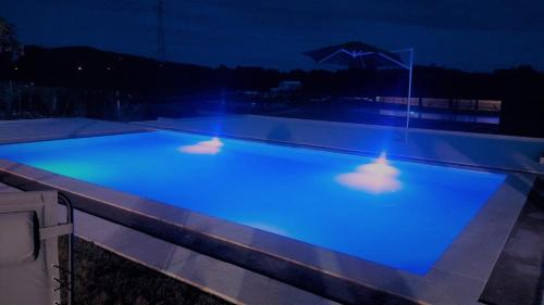 a swimming pool with blue lighting at night at Quinta Lourena - Casa do Caseiro in Covilhã