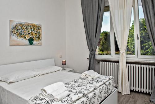 a white bedroom with a bed and a window at “villa Francesco” in Nizza Monferrato