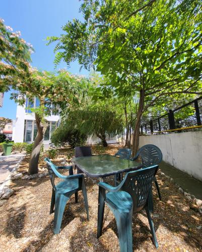 a table and two chairs and a table and trees at La Perla Bianca Residence in Eforie Nord