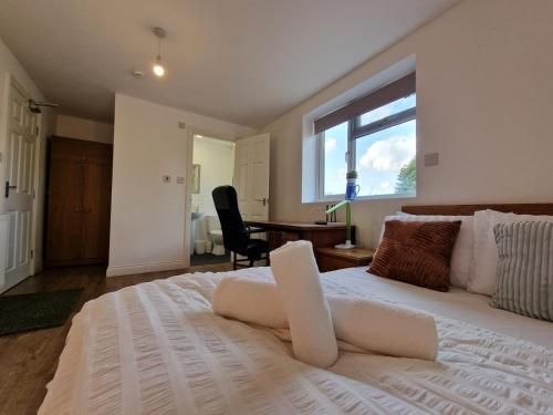 a bedroom with a large white bed and a desk at Nice Living Serviced Accommodations 8 (Entire 2 Ensuite Bedroom House) in Coventry
