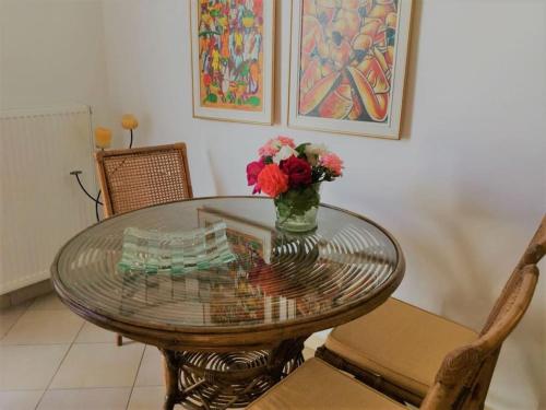 a glass table with a vase of flowers on it at Paros spacious apartment in Prodromos Paros