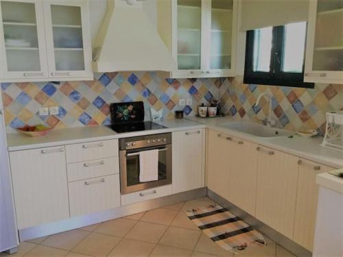 a kitchen with white cabinets and a stove at Paros spacious apartment in Prodromos Paros